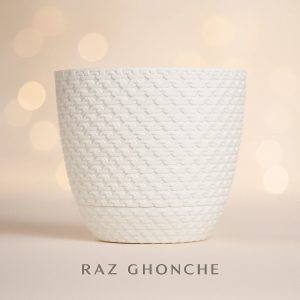 White plastic plant pot with a woven texture pattern, displayed against a soft beige background with warm bokeh lights.
