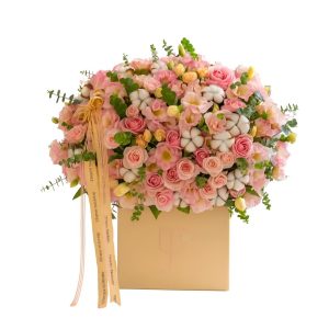 Luxury peach and pink rose flower box with cotton flowers and eucalyptus in a cream premium box.