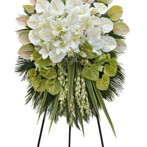 Luxury white-green ceremonial floral stand with white lilies, green anthuriums and premium greenery on a tall black stand.