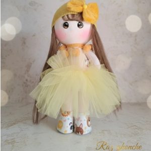 yellow russian cloth doll with long brown hair, tulle skirt, matching knitted headband and bow, cartoon‑printed boots, RAZ GHONCHE