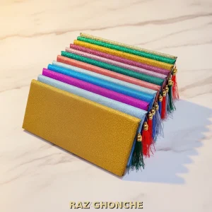 colorful glitter gift envelopes with tassel ornaments arranged in a stack