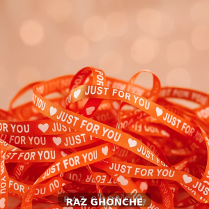 orange gift ribbon with white text “JUST FOR YOU” and heart symbols on bokeh background